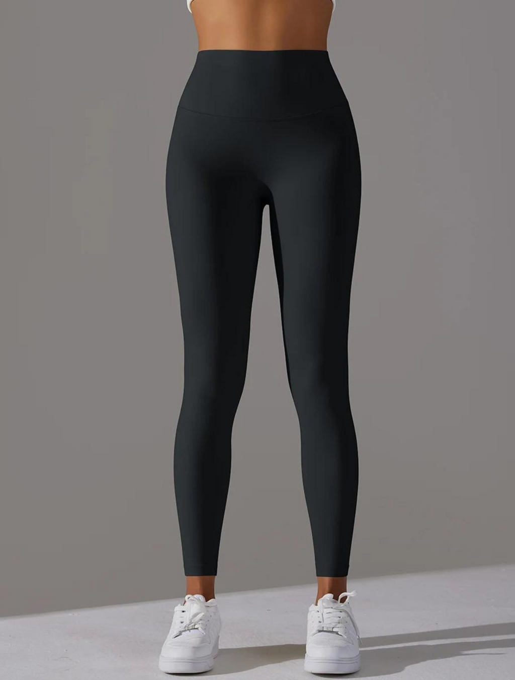 Calça legging preta de cintura alta, projetada para proporcionar conforto e suporte durante atividades físicas, com tecido elástico e acabamento sem costura para maior mobilidade e estilo.