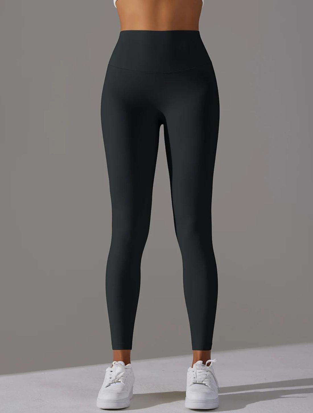 Calça legging preta de cintura alta, projetada para proporcionar conforto e suporte durante atividades físicas, com tecido elástico e acabamento sem costura para maior mobilidade e estilo.